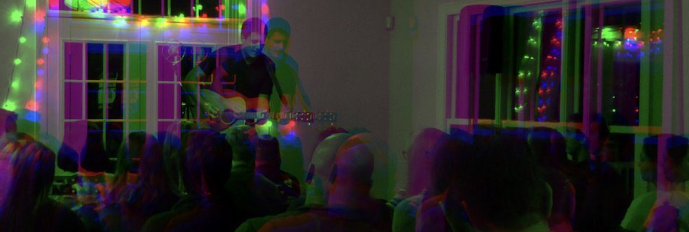 A blurred, layered frame of a room mid-song