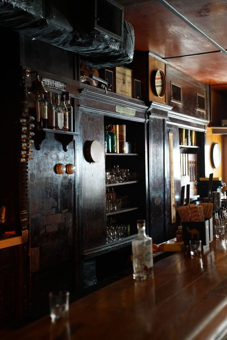 A violin hung above rows of glassware on the dark back bar